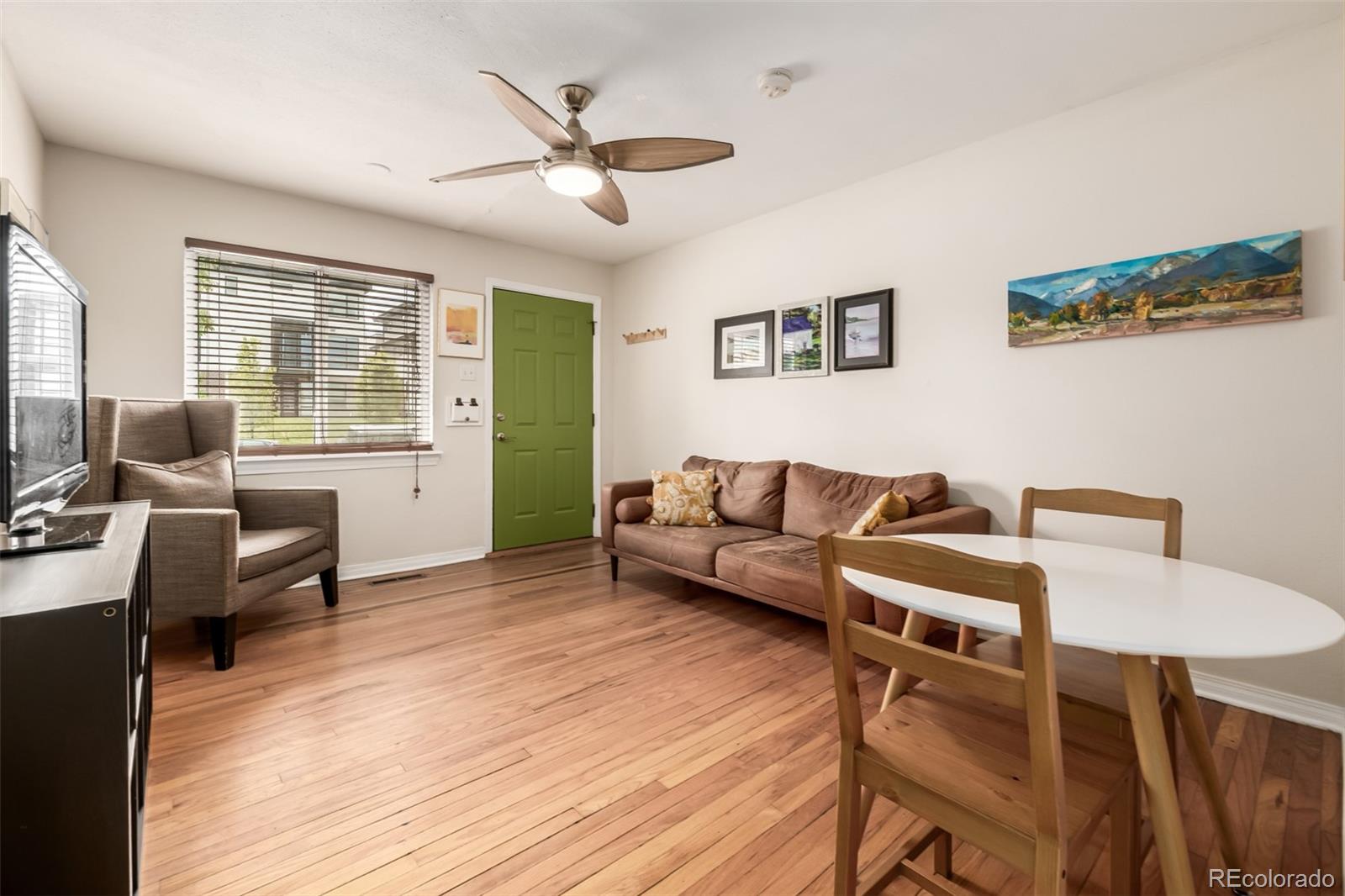 a living room with furniture and a wooden floor