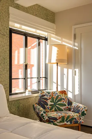 a bedroom with a bed a mirror on dresser and a chandelier