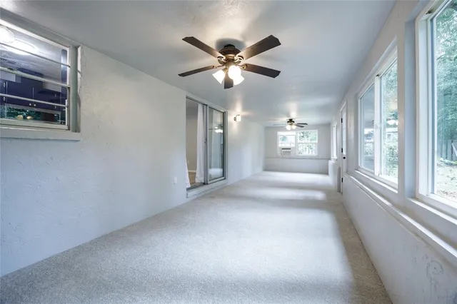 a view of a big room with chandelier fan and windows