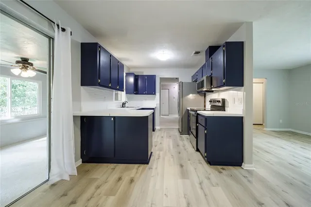 a kitchen with stainless steel appliances a stove microwave and cabinets