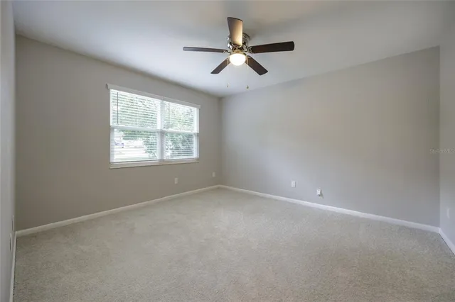 an empty room with closet and windows