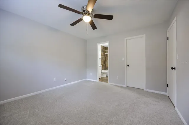 a view of an empty room with closet and mirror