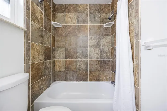 an empty room with chandelier fan