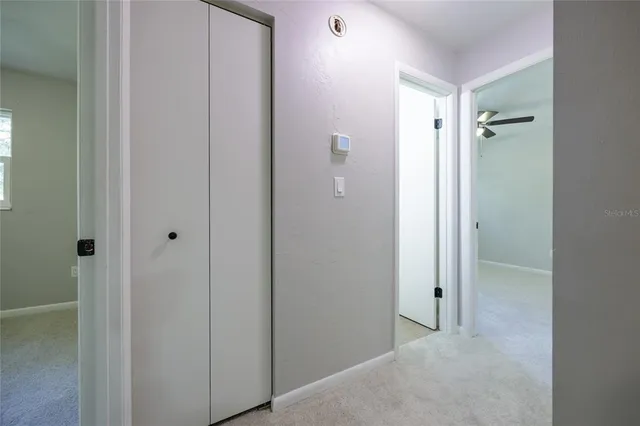 an empty room with a ceiling fan and a window