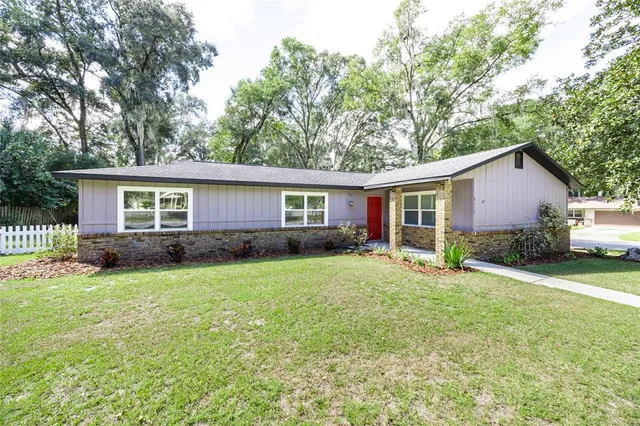 a view of a house with a yard and trees
