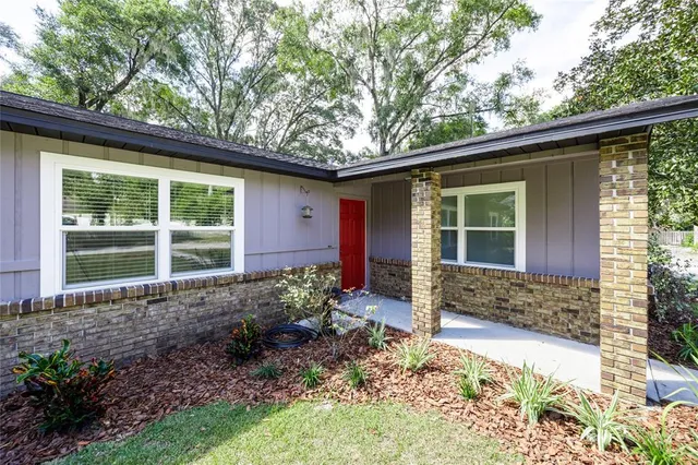 a view of a hallway with wooden floor and a bathroom