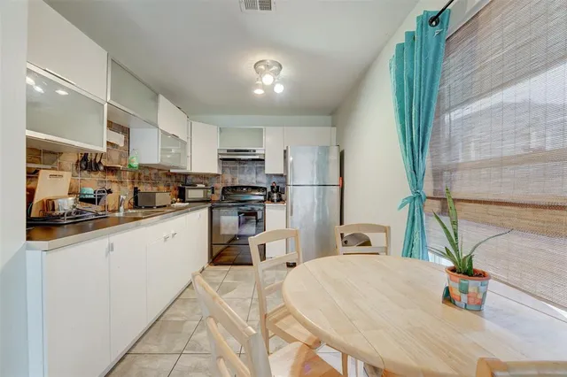 a kitchen with sink a refrigerator and microwave