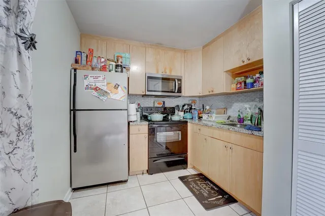 a kitchen with a refrigerator and a stove top oven