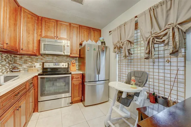 a kitchen with stainless steel appliances granite countertop a refrigerator a stove a sink and dishwasher