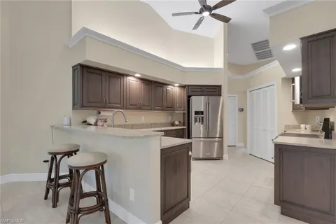 a kitchen with refrigerator a sink and chairs