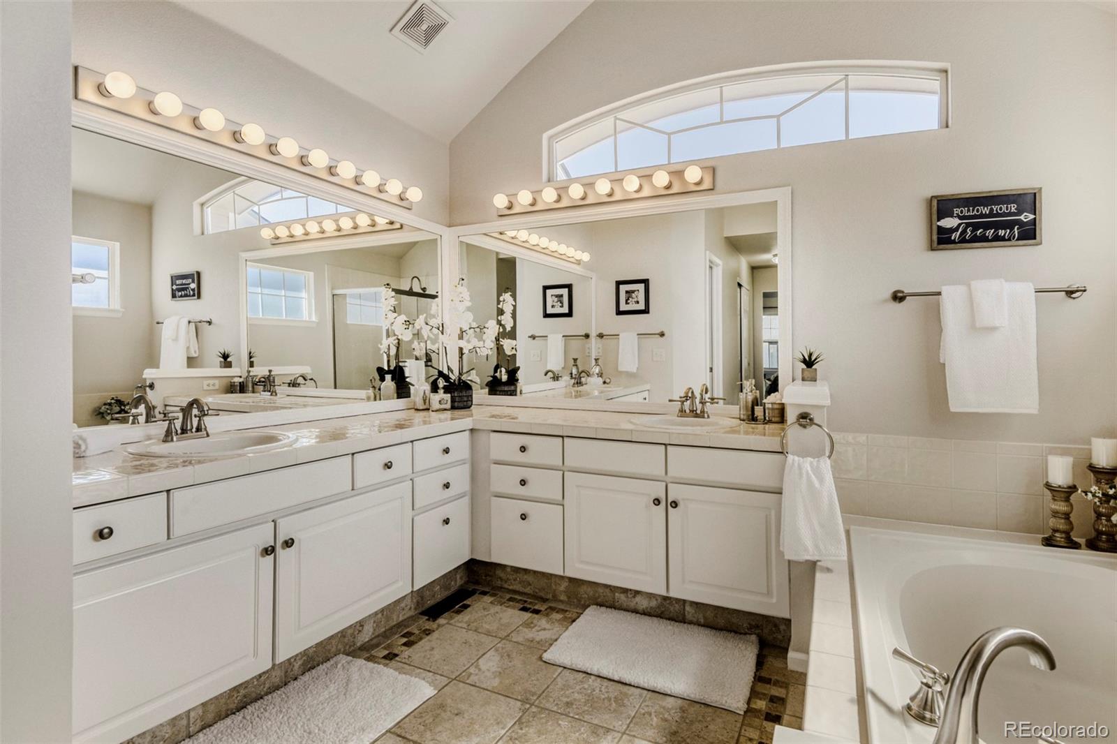 8573 South Mallard Court Highlands Ranch, CO 80126 - Photo 21 of 50 a spacious bathroom with a granite countertop sink a mirror a lamp and bathtub