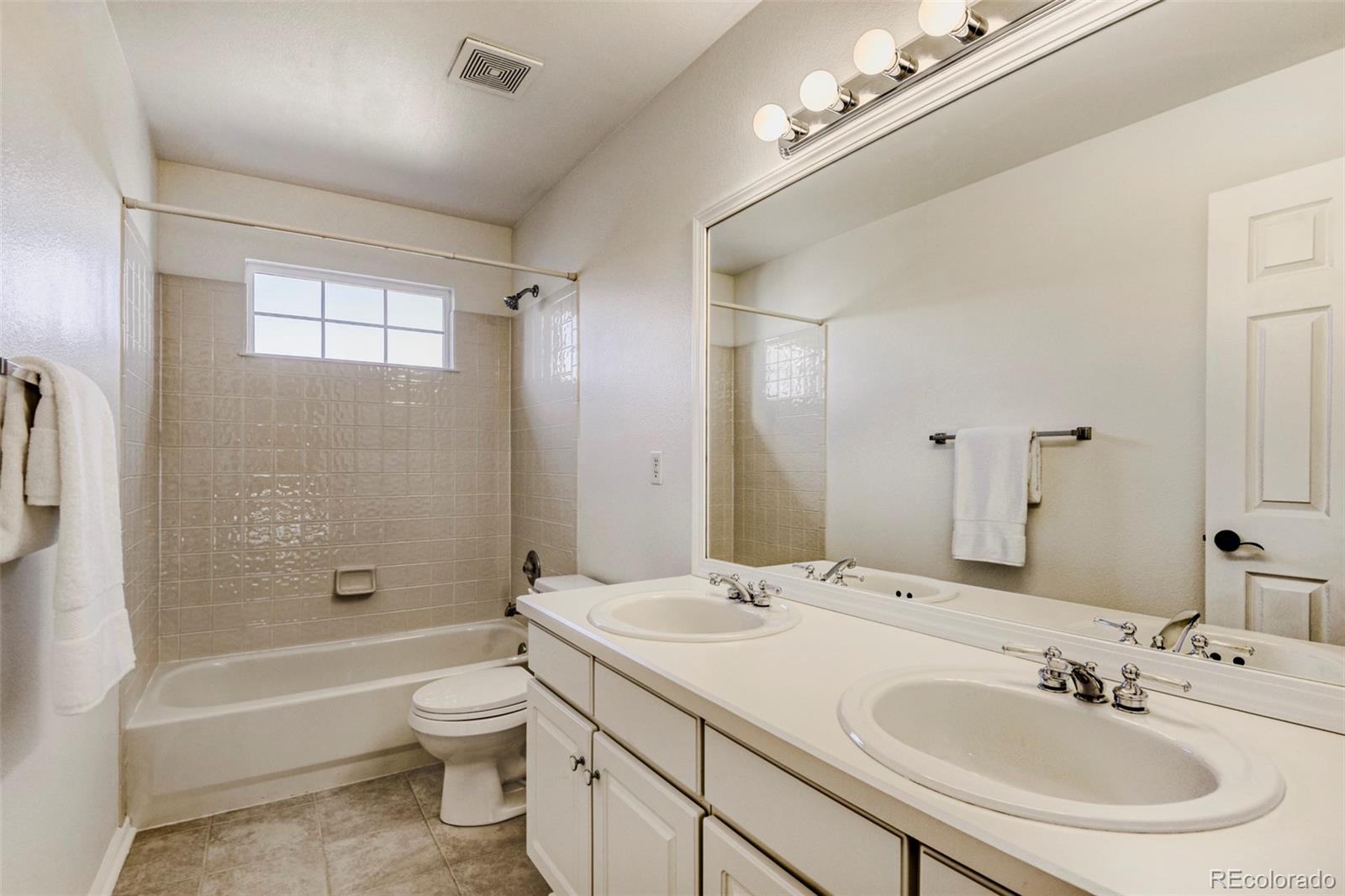 8573 South Mallard Court Highlands Ranch, CO 80126 - Photo 26 of 50 a bathroom with a sink a toilet a mirror and bathtub