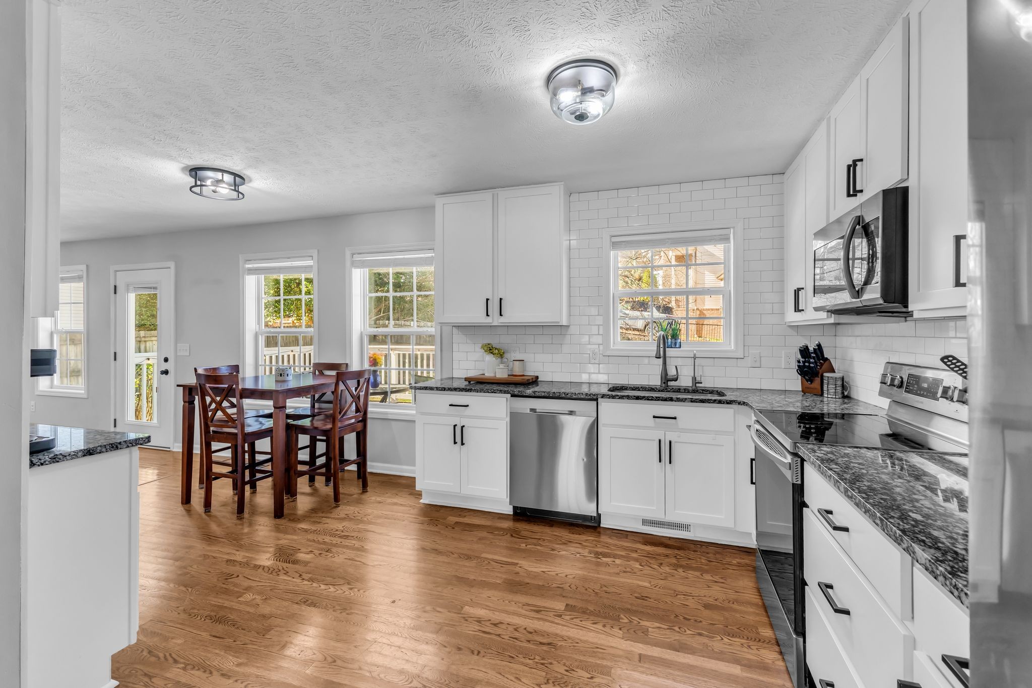 2005 Trenton Drive Spring Hill, TN 37174 - Photo 10 of 35 a kitchen with granite countertop a stove top oven a sink a dining table and chairs