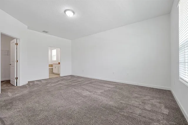 an empty room with windows and closet