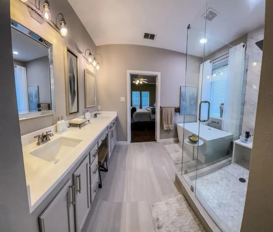 1391 Riverside Oaks Drive Rockwall, TX 75087 - Photo 21 of 32 a large bathroom with a double vanity sink a large mirror and a bathtub