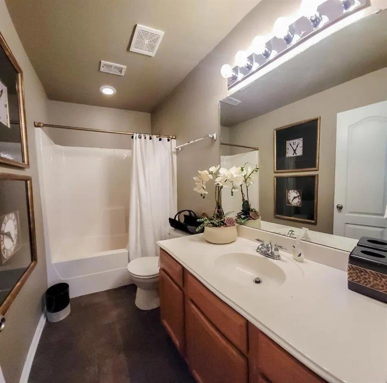 1391 Riverside Oaks Drive Rockwall, TX 75087 - Photo 26 of 32 a bathroom with a double vanity sink a toilet and a mirror