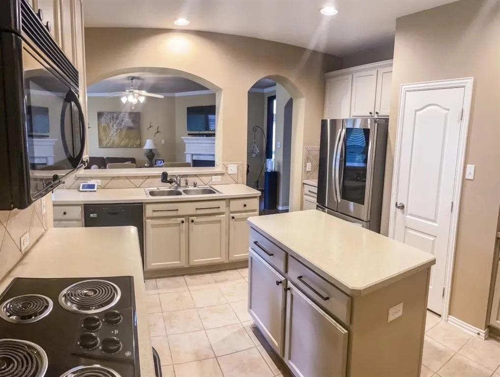 1391 Riverside Oaks Drive Rockwall, TX 75087 - Photo 6 of 32 a kitchen with a stove a sink and a refrigerator
