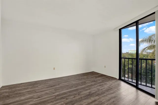 an empty room with wooden floor and a window