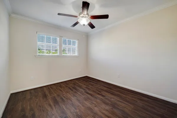 a view of an empty room with a window and wooden floor