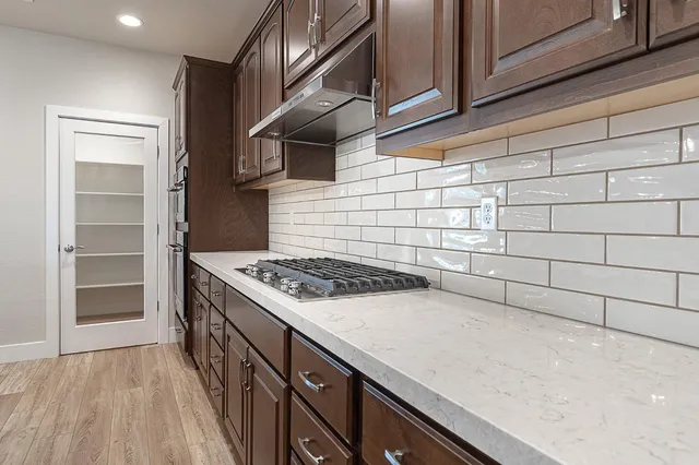 a kitchen with granite countertop a stove and a wooden cabinets