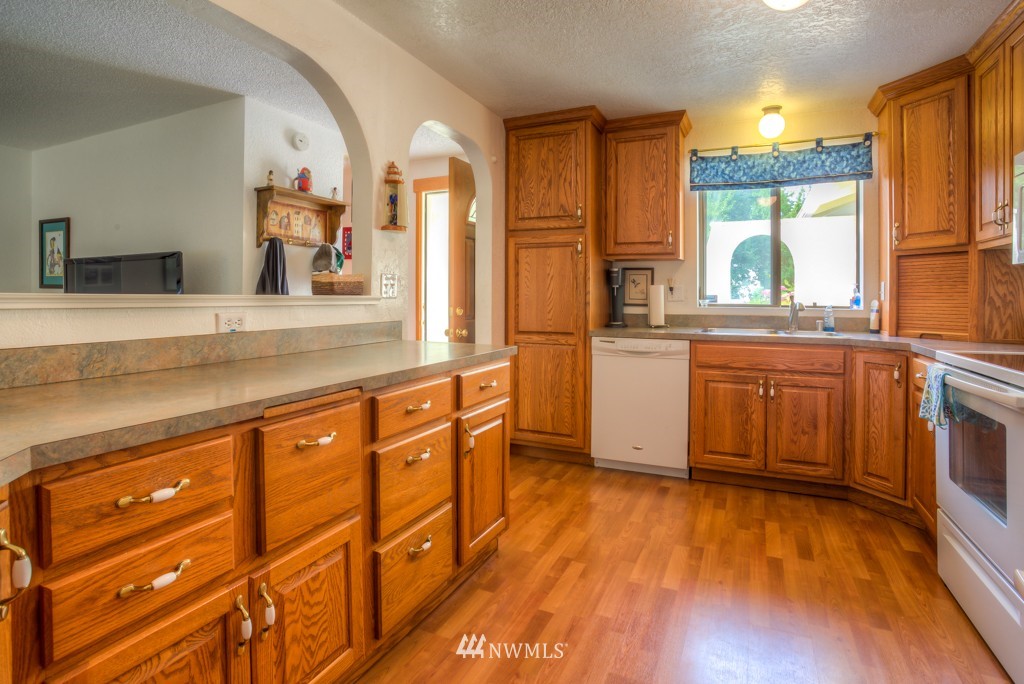 2833 Morris Avenue South Renton, WA 98055 - Photo 7 of 16 a kitchen with stainless steel appliances granite countertop a stove a sink and white cabinets with wooden floor