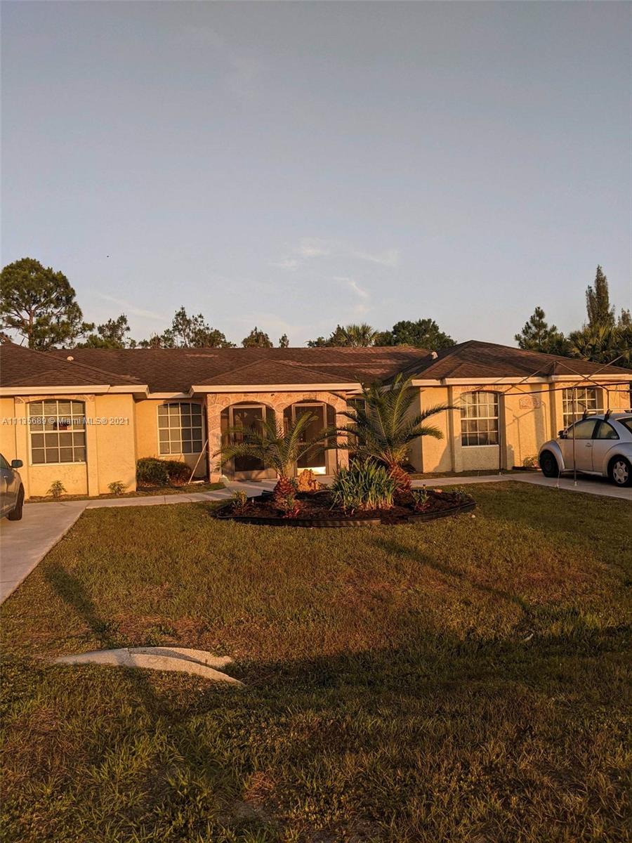 3973-3975 Sunset Road Lehigh Acres, FL 33971 - Photo 1 of 14 a view of a house with backyard porch and furniture