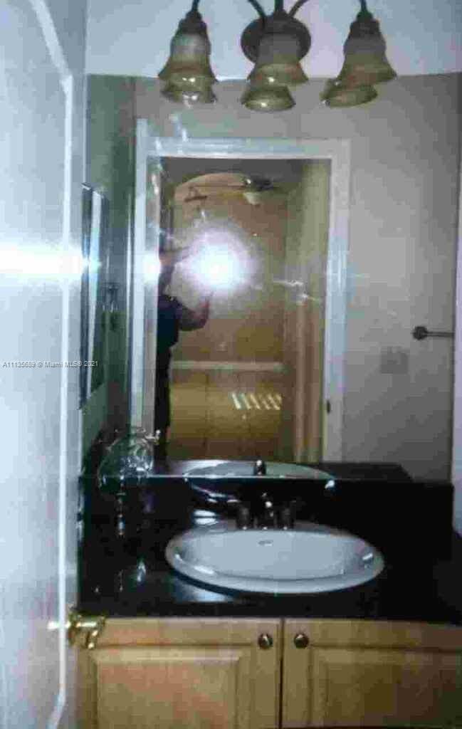 3973-3975 Sunset Road Lehigh Acres, FL 33971 - Photo 14 of 14 a bathroom with a sink and a mirror