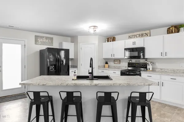 a living room with furniture and kitchen view