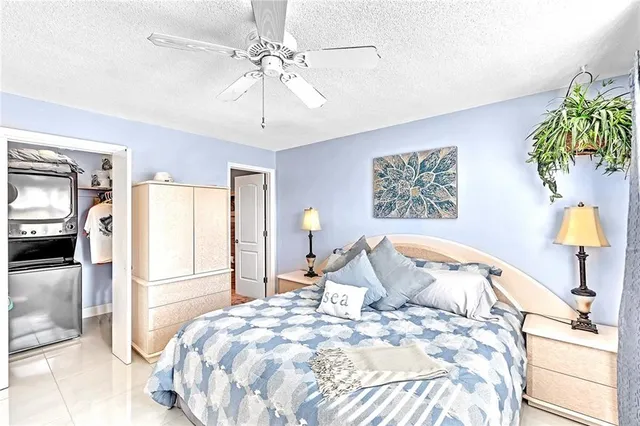 a spacious bedroom with a large bed a chandelier and a rug