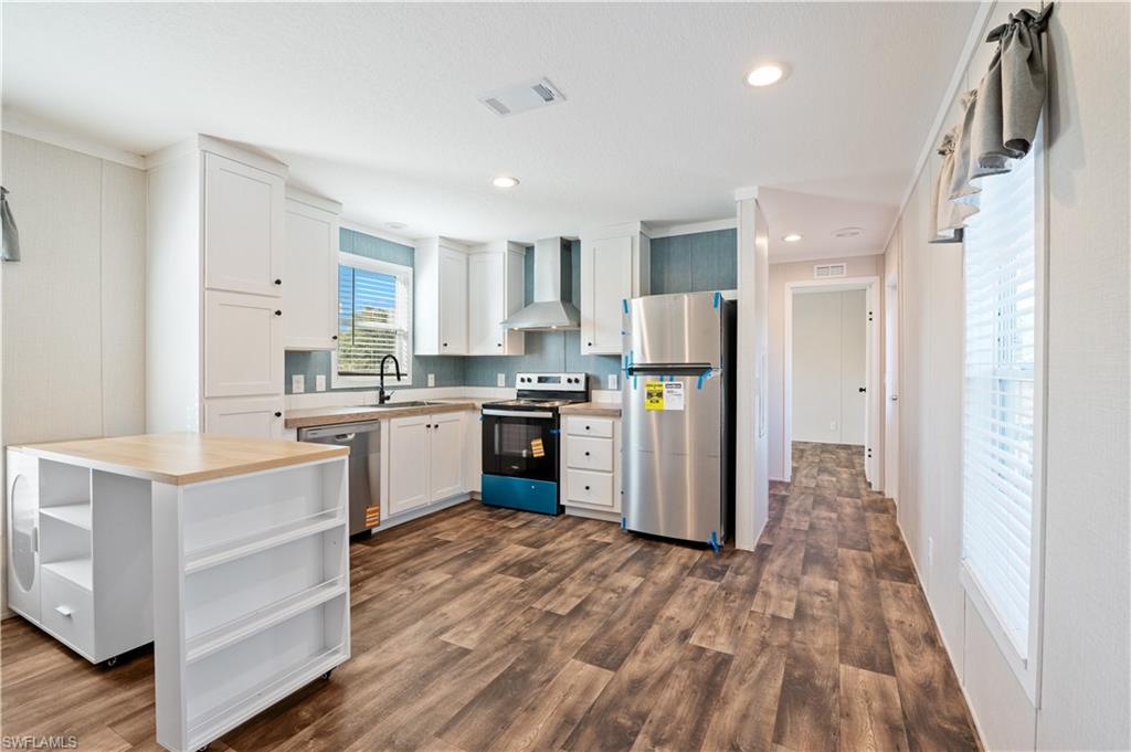 325 North Sendero Street Clewiston, FL 33440 - Photo 5 of 10 a kitchen with a refrigerator a sink and cabinets