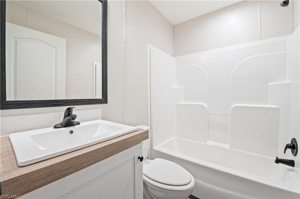 325 North Sendero Street Clewiston, FL 33440 - Photo 9 of 10 a bathroom with a sink a toilet and a bathtub
