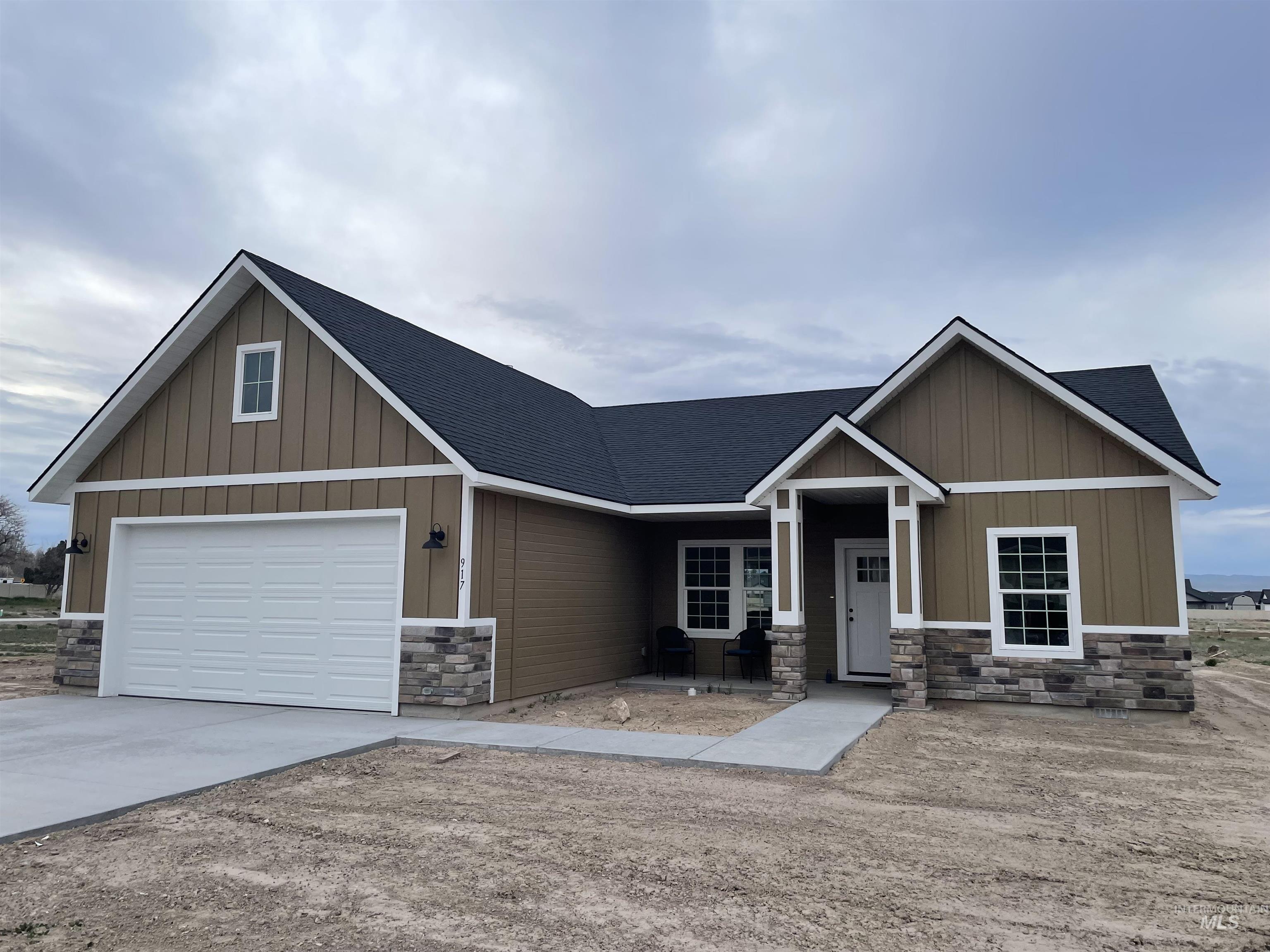 Craftsman house featuring board and batten siding, stone siding, driveway, and a shingled roof