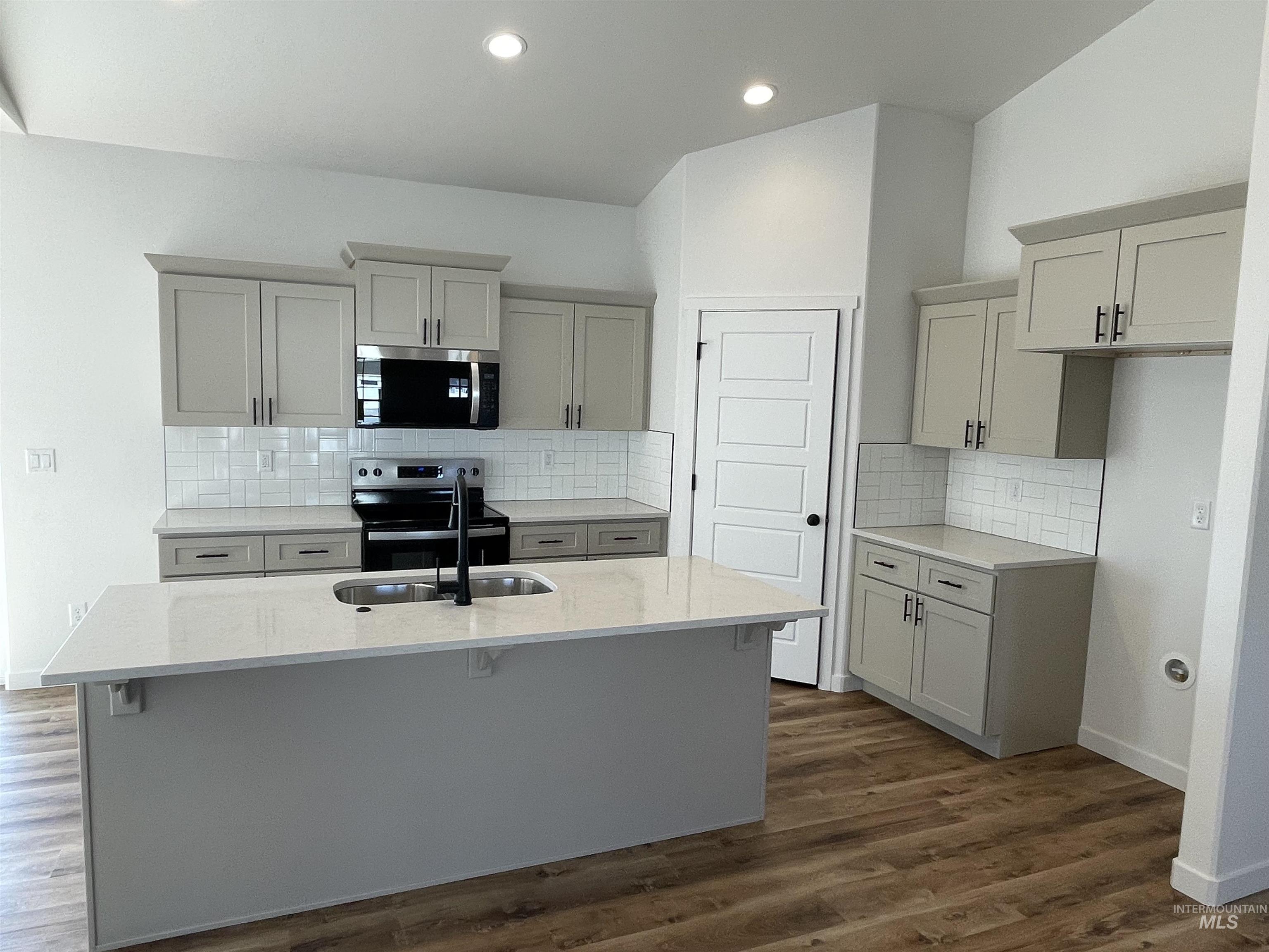 917 Quartz Road Kimberly, ID 83341 - Photo 2 of 12 Kitchen with light stone counters, tasteful backsplash, stainless steel appliances, dark wood-style floors, and gray cabinetry