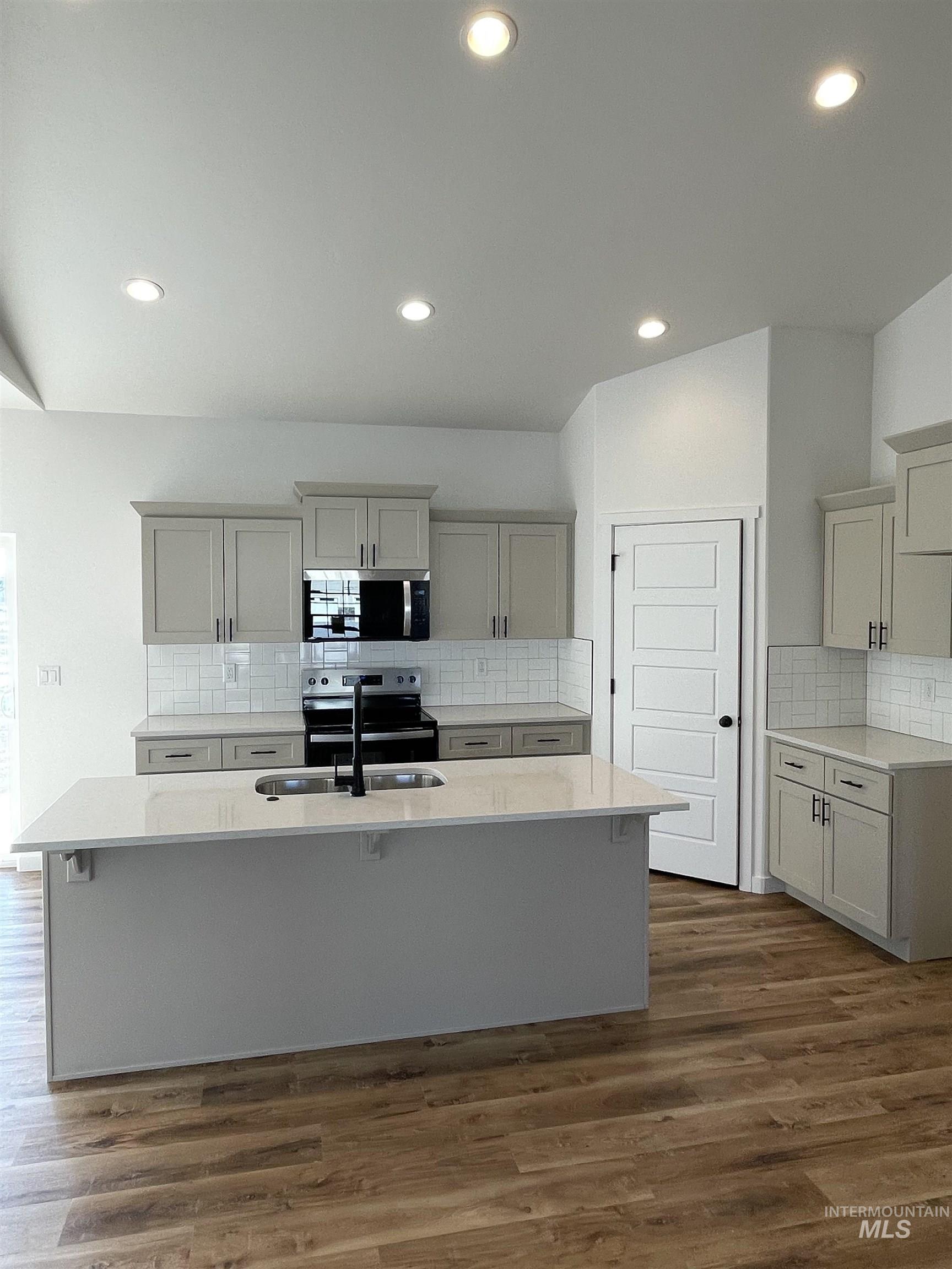 917 Quartz Road Kimberly, ID 83341 - Photo 3 of 12 Kitchen featuring backsplash, light stone countertops, a kitchen island with sink, stainless steel appliances, and recessed lighting
