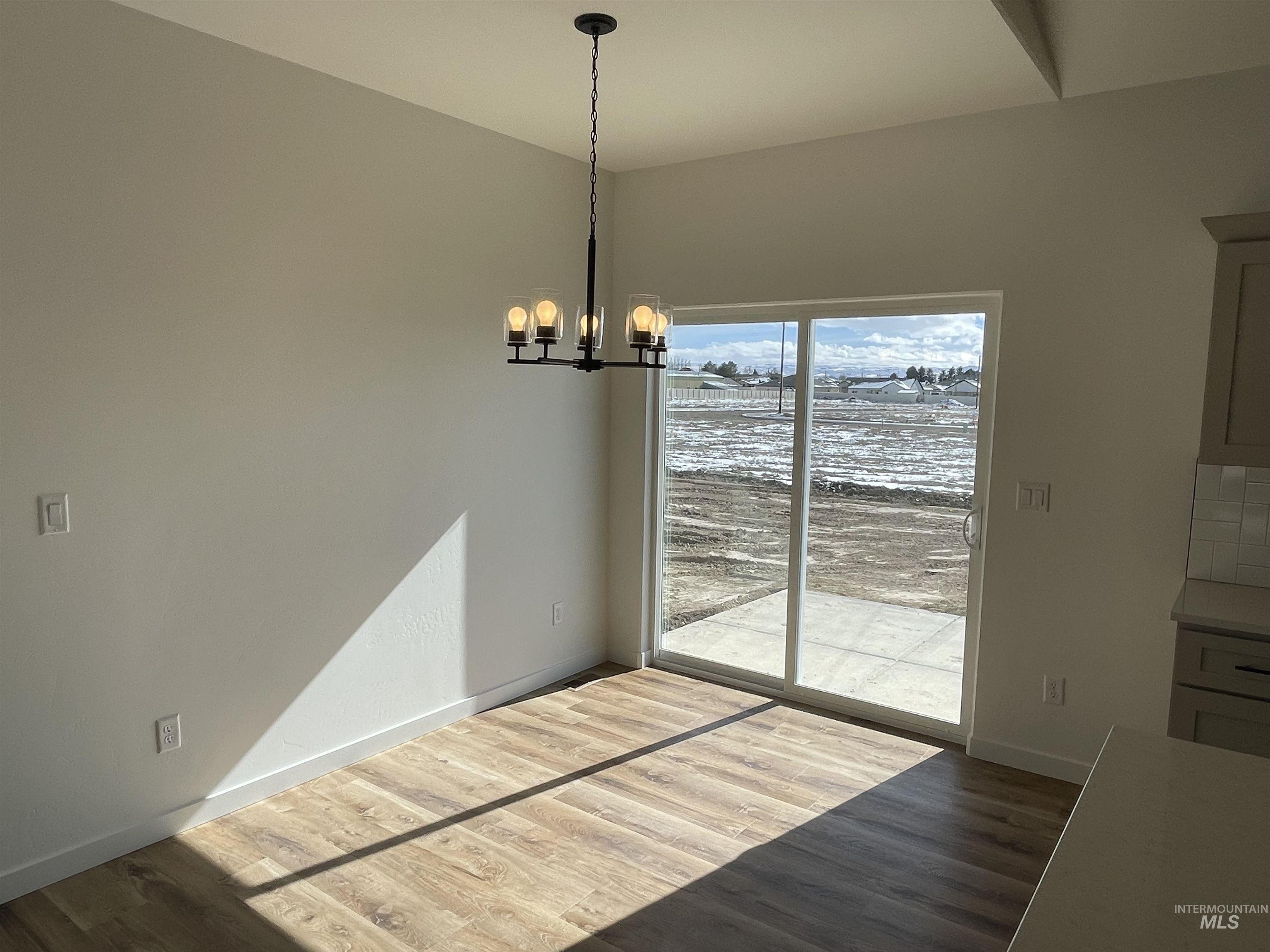 917 Quartz Road Kimberly, ID 83341 - Photo 4 of 12 Unfurnished dining area with wood finished floors and a chandelier