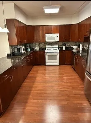 a kitchen with wooden floors and wooden cabinets