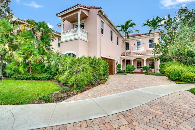 a front view of a house with a yard and potted plants