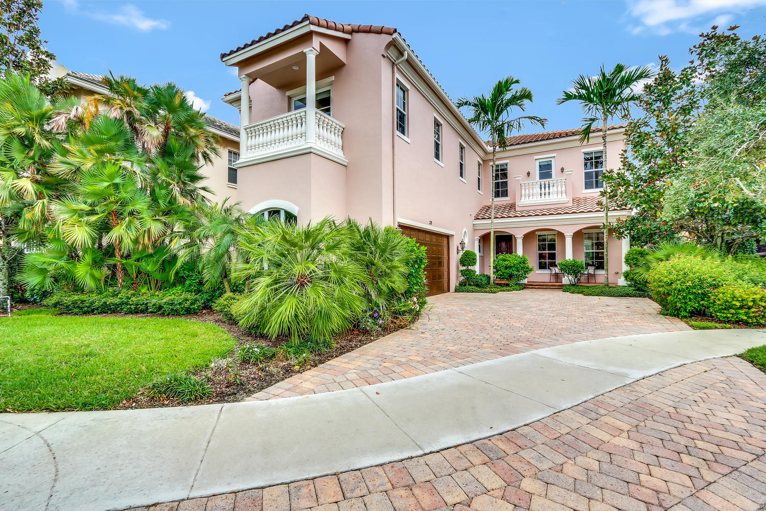 128 Tulip Tree Court Jupiter, FL 33458 - Photo 1 of 35 a front view of a house with a yard and potted plants