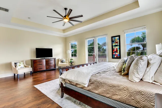 a bedroom with a bed a couch and a flat screen tv