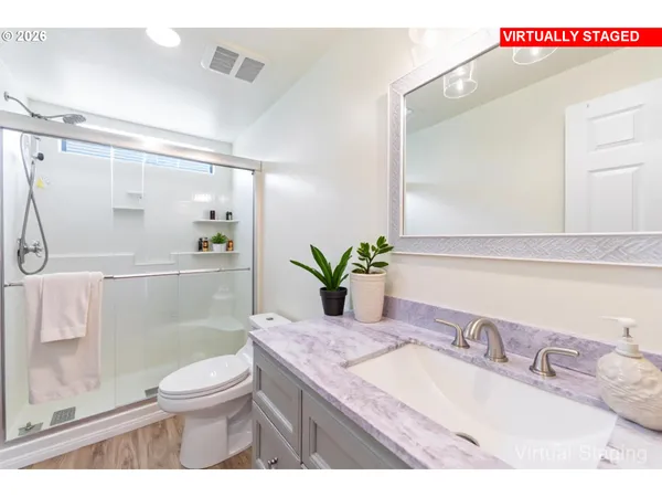 a bathroom with a granite countertop sink a toilet and shower