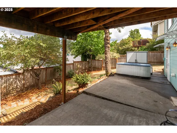 a view of a backyard with plants and wooden fence