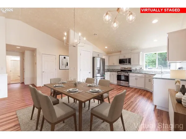 a kitchen with stainless steel appliances kitchen island granite countertop a dining table chairs and stove