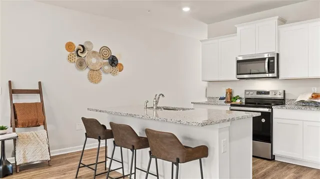 a kitchen with kitchen island granite countertop a sink cabinets and stainless steel appliances