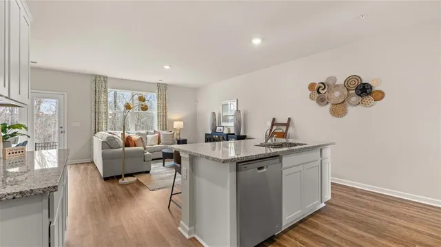 a living room with furniture a wooden floor and a sink