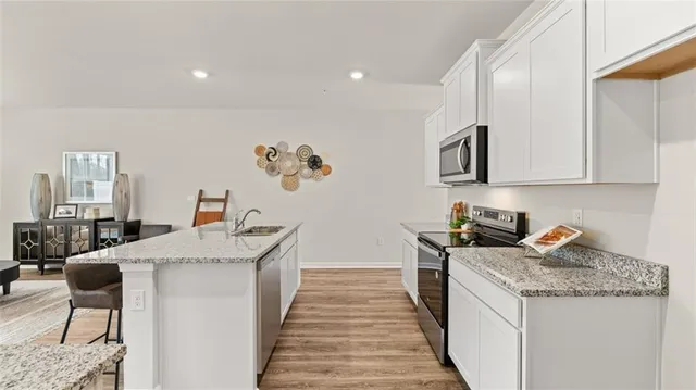 a kitchen with granite countertop a sink stove and cabinets