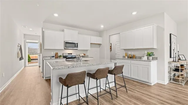a kitchen with white cabinets and stainless steel appliances