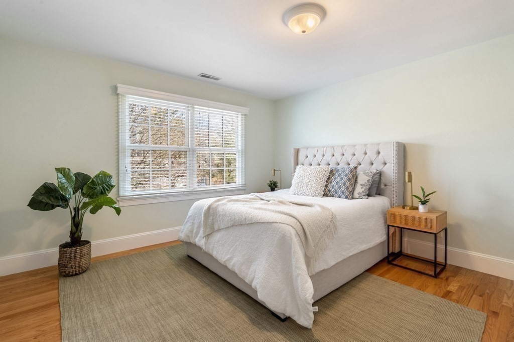 51 Baker Place Newton, MA 02462 - Photo 24 of 38 a bedroom with a bed and a potted plant