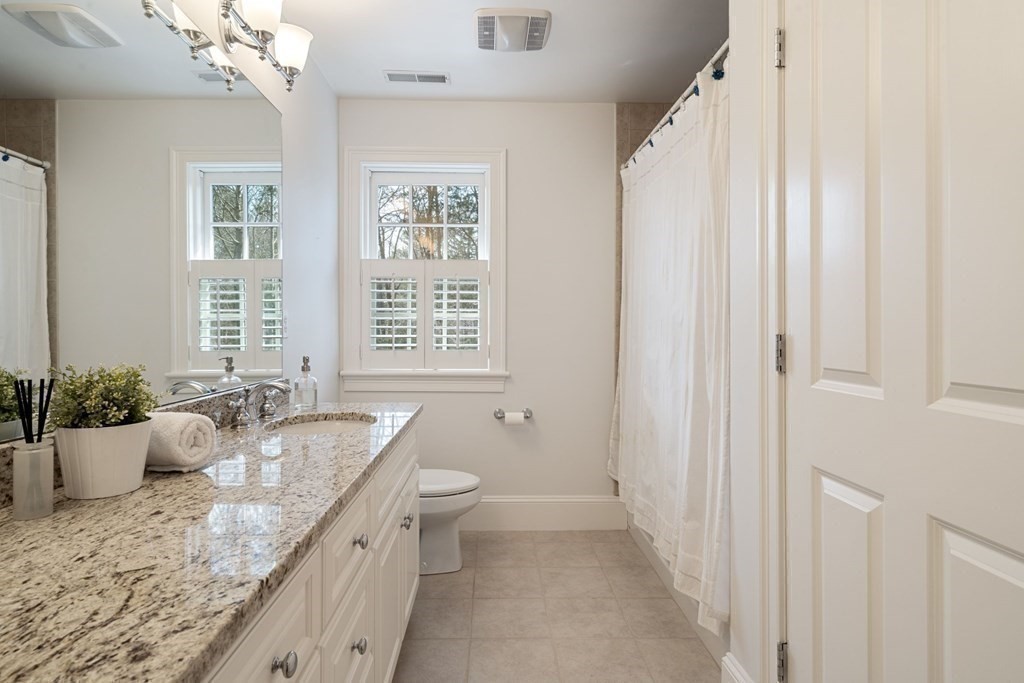 51 Baker Place Newton, MA 02462 - Photo 25 of 38 a bathroom with a granite countertop sink a large mirror and a bathtub