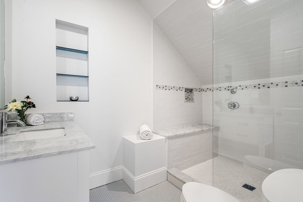 51 Baker Place Newton, MA 02462 - Photo 32 of 38 a bathroom with a granite countertop sink a toilet and shower