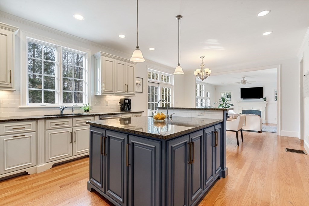 51 Baker Place Newton, MA 02462 - Photo 10 of 38 a kitchen with stainless steel appliances granite countertop a stove a sink dishwasher and a wooden cabinets with wooden floor